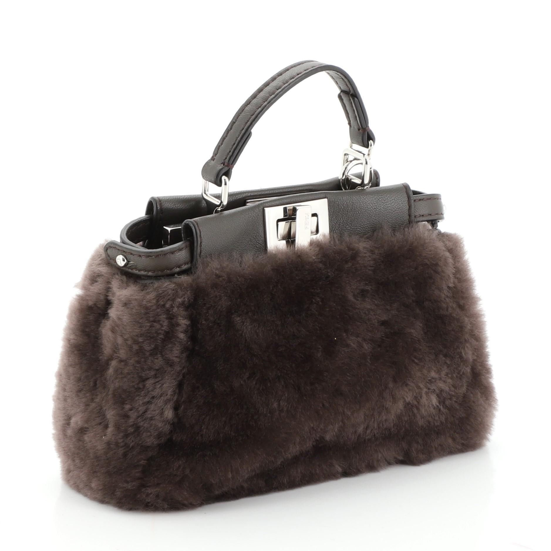 This Fendi Peekaboo Bag Fur Micro, crafted from brown fur, features a top frame silhouette, flat leather handle, dual compartments with turn-lock and snap closures, and silver-tone hardware. It opens to a neutral microfiber interior with side slip