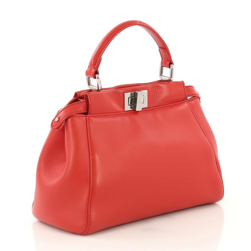 This Fendi Peekaboo Bag Leather Mini, crafted from red leather, features a leather top handle and silver-tone hardware. Its turn-lock and snap closures open to a red leather interior with dual compartments and side zip pocket.  

Estimated Retail