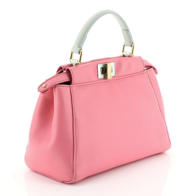 This Fendi Peekaboo Bag Leather Mini, crafted from pink leather, features a leather top handle and gold-tone hardware. Its turn-lock and snap closure opens to a gray leather interior with dual compartments. 

Estimated Retail Price: