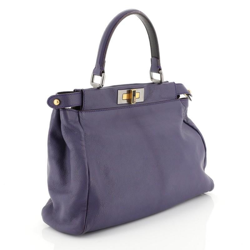 This Fendi Peekaboo Bag Ombre Leather Regular, crafted from purple ombre leather, features a short leather top handle, framed top, and matte silver and gold-tone hardware. Its two compartments with turn-lock and zip closures open to a brown coated
