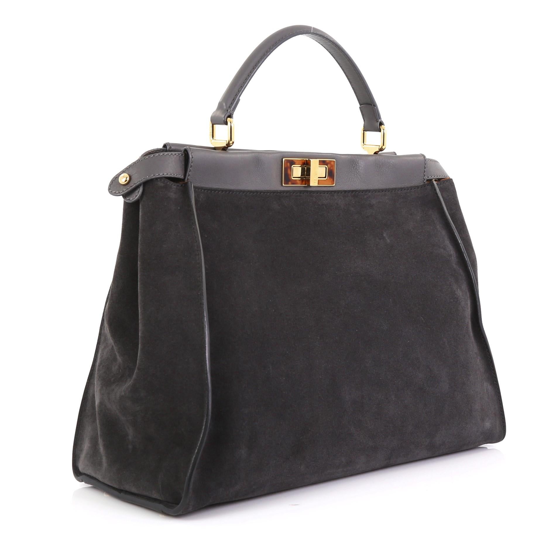 This Fendi Peekaboo Bag Suede with Calf Hair Interior Large, crafted from gray sude, features short leather top handle, protective base studs, and gold-tone hardware. Its two compartments with turn-lock and zip closures open to a gray raw leather