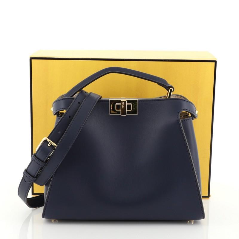 This Fendi Peekaboo Essentially Bag Leather, crafted from blue leather, features a short leather top handle, framed top, and gold-tone hardware. Its two compartments with turn-lock closures open to a neutral leather interior with side zip pocket.