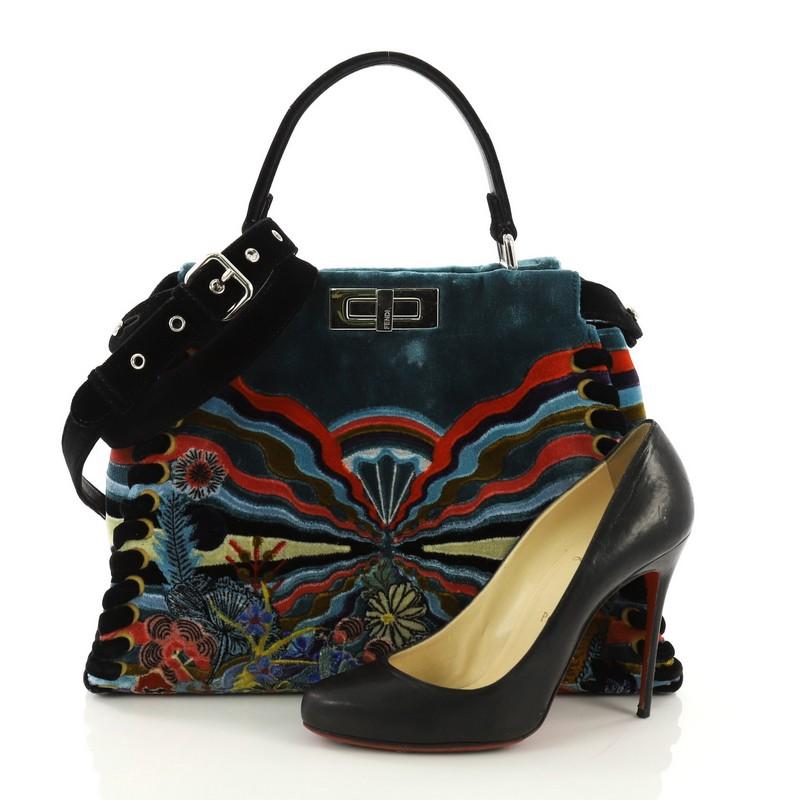 This Fendi Peekaboo Handbag Embroidered Velvet Medium, crafted from multicolor embroidered velvet, features a top frame silhouette, flat top handle, protective base studs, and silver-tone hardware. Its turn-lock and magnetic snap closures open to a