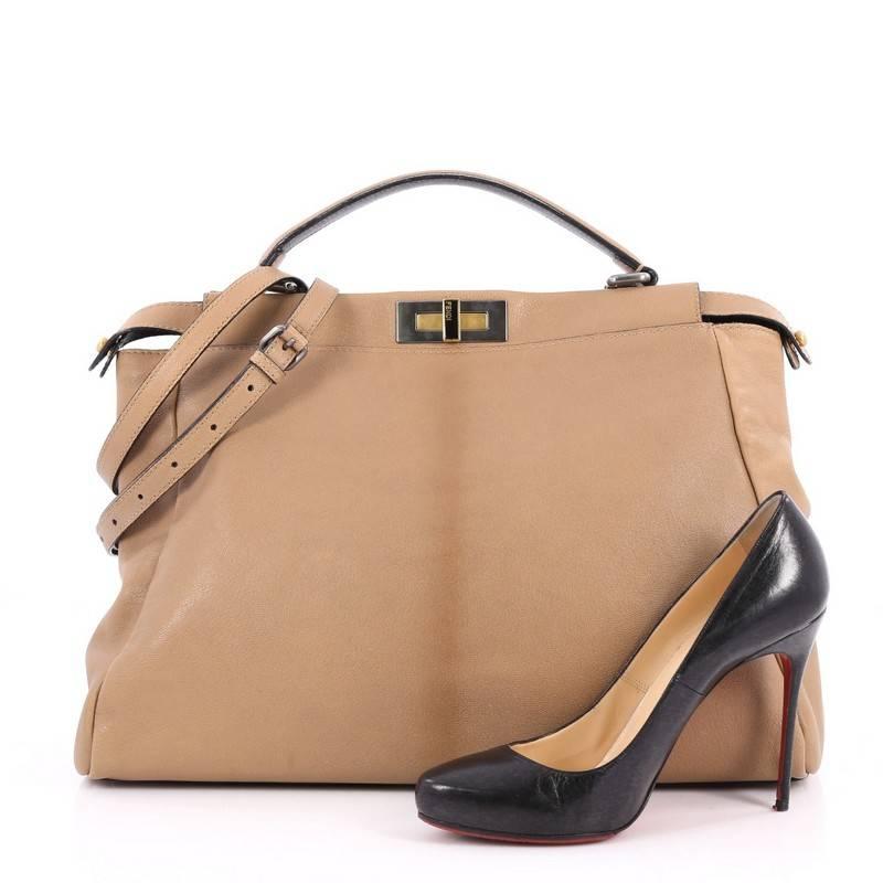 This authentic Fendi Peekaboo Handbag Leather Large is one of Fendi's best-known designs exuding a luxurious yet minimalist appearance. Crafted in light brown leather, this versatile and stylish satchel features a flat leather top handle, protective