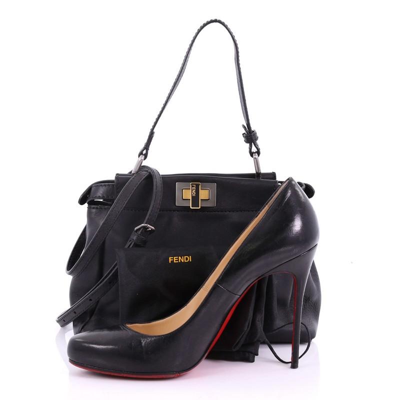 This Fendi Peekaboo Handbag Leather Mini, crafted in black leather, features a flat leather top handle and gold and gunmetal-tone hardware. Its turn-lock closures on both sides open to a black suede interior with side zip pocket. **Note: Shoe