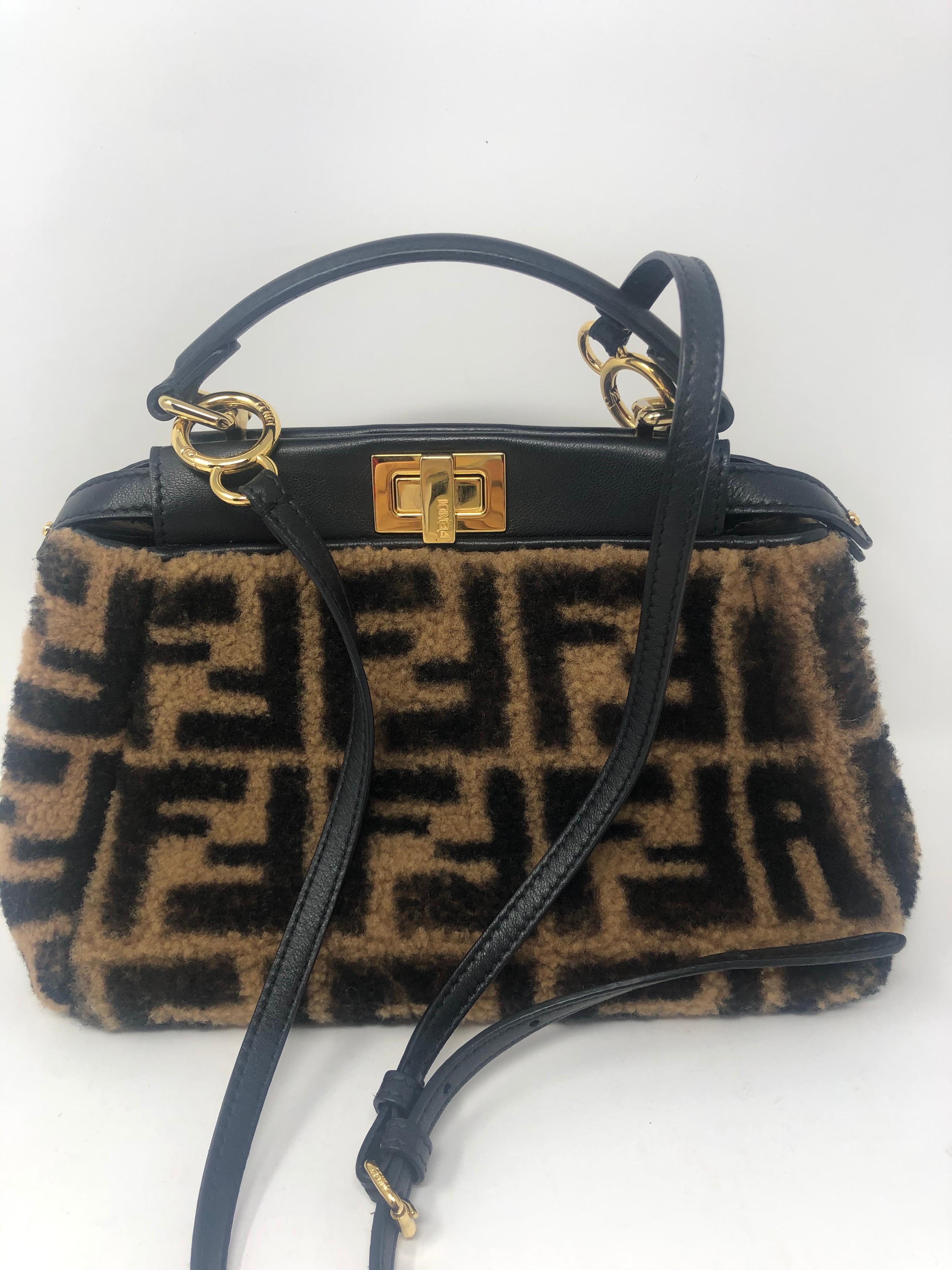 Fendi Peekaboo Iconic Mini Sheepskin Fur Crossbody Bag. Shearling fur with FF motif. Strap and interior made of black nappa leather. Gold tone details. Good condition. Unique style and most wanted mini size style bag. Trending over retail $4200