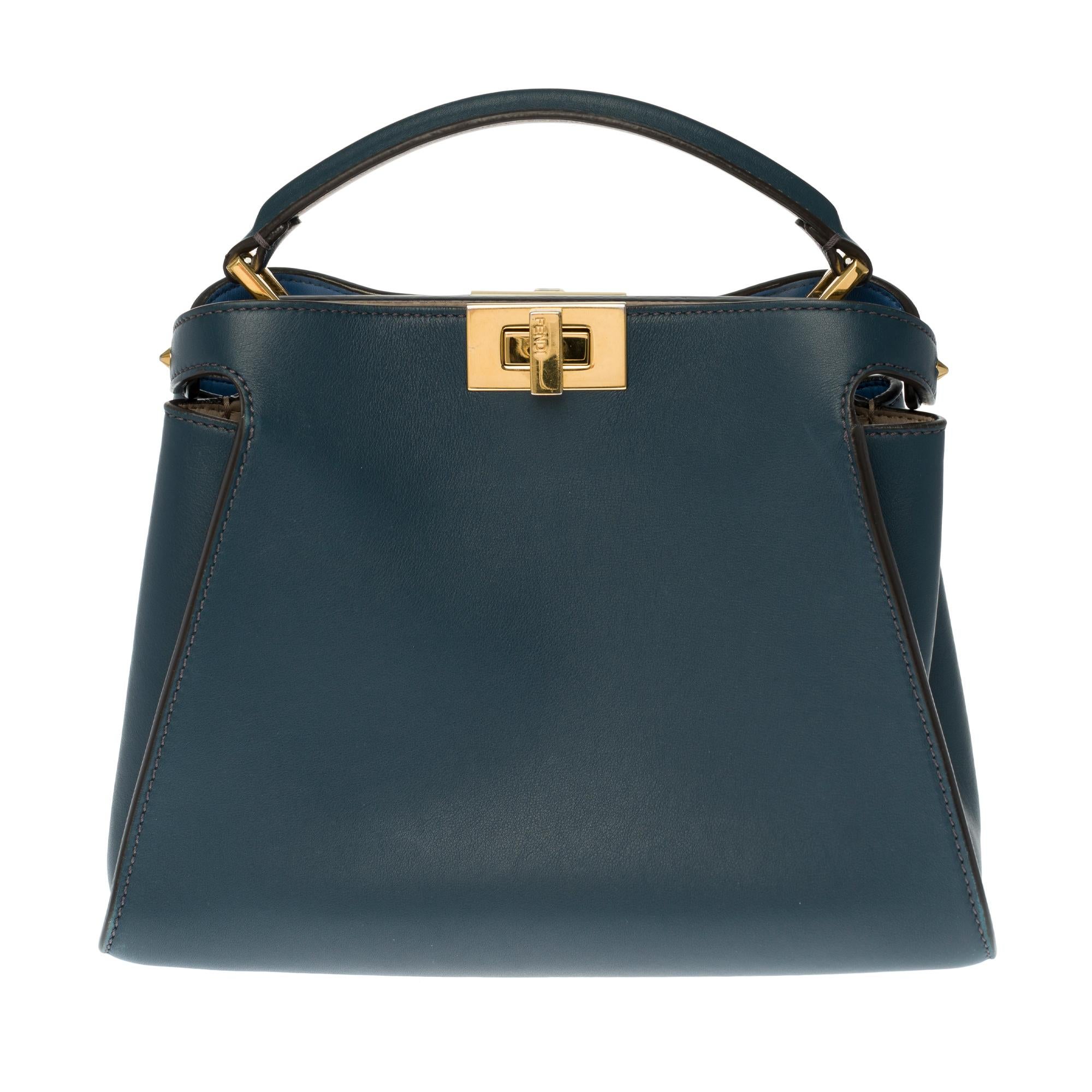 The highly sought-after Fendi Peekaboo shoulder bag in blue leather, gold metal hardware, blue leather handle, blue leather removable shoulder strap handle allowing a hand or shoulder or shoulder strap.

Closing by swivel button.
Lining in taupe