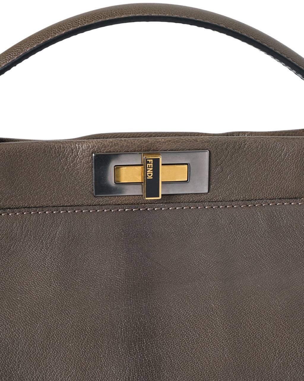 Die charakteristische Tasche von Fendi, das Modell Peekaboo, in der mittleren Größe, ist ein authentisches Symbol für Eleganz und Raffinesse. Aus weichem Leder in Schlammfarbe mit schwarzen Einsätzen und silbernen Beschlägen. Ausgestattet mit einem