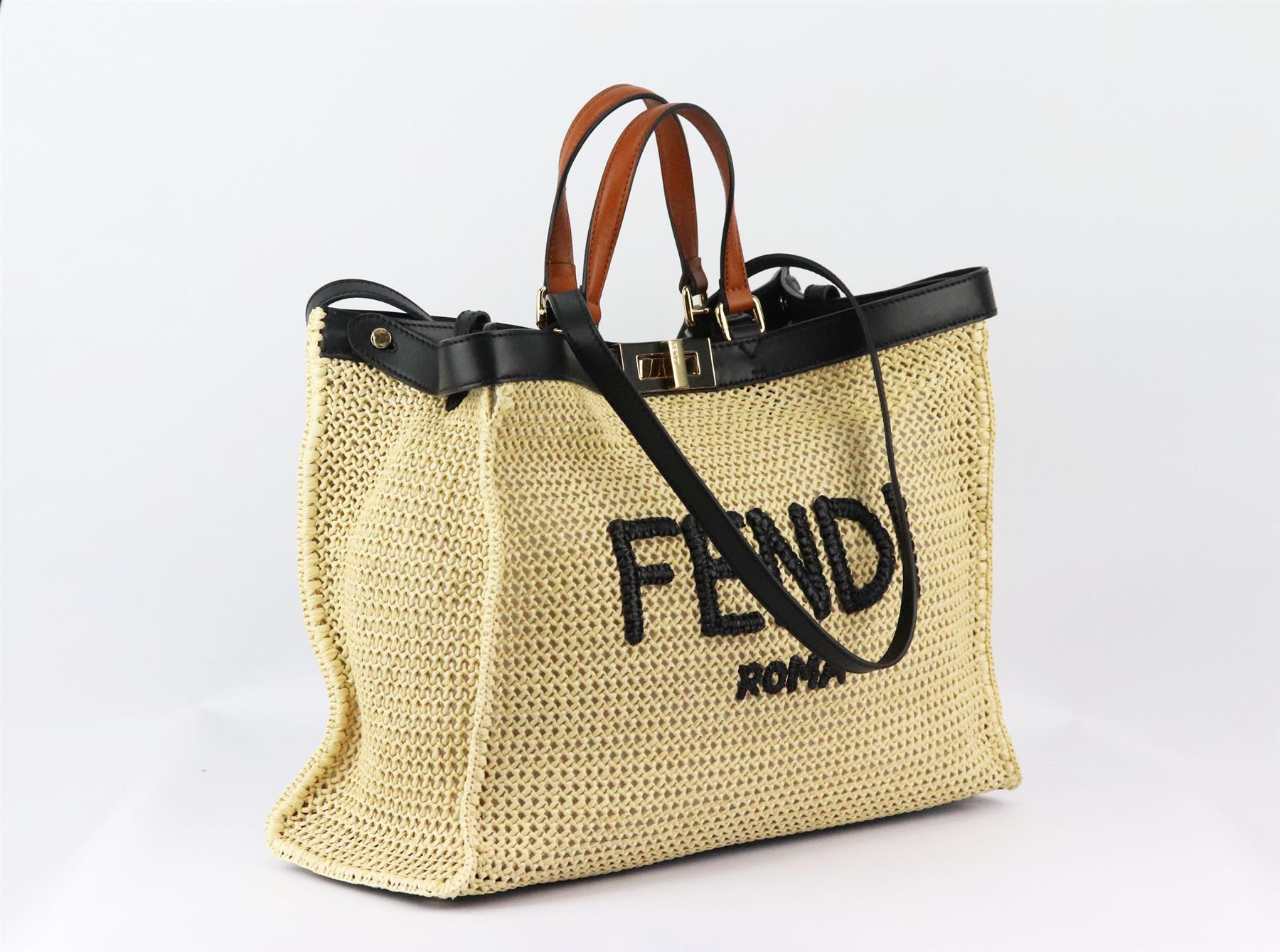 This iconic 'Peekaboo’ X-Tote' Medium tote bag by Fendi gets a trendy update in beige straw with a woven logo motif on the front, trimmed with black and brown leather and decorated with the classic twist lock, it has a large internal compartment and