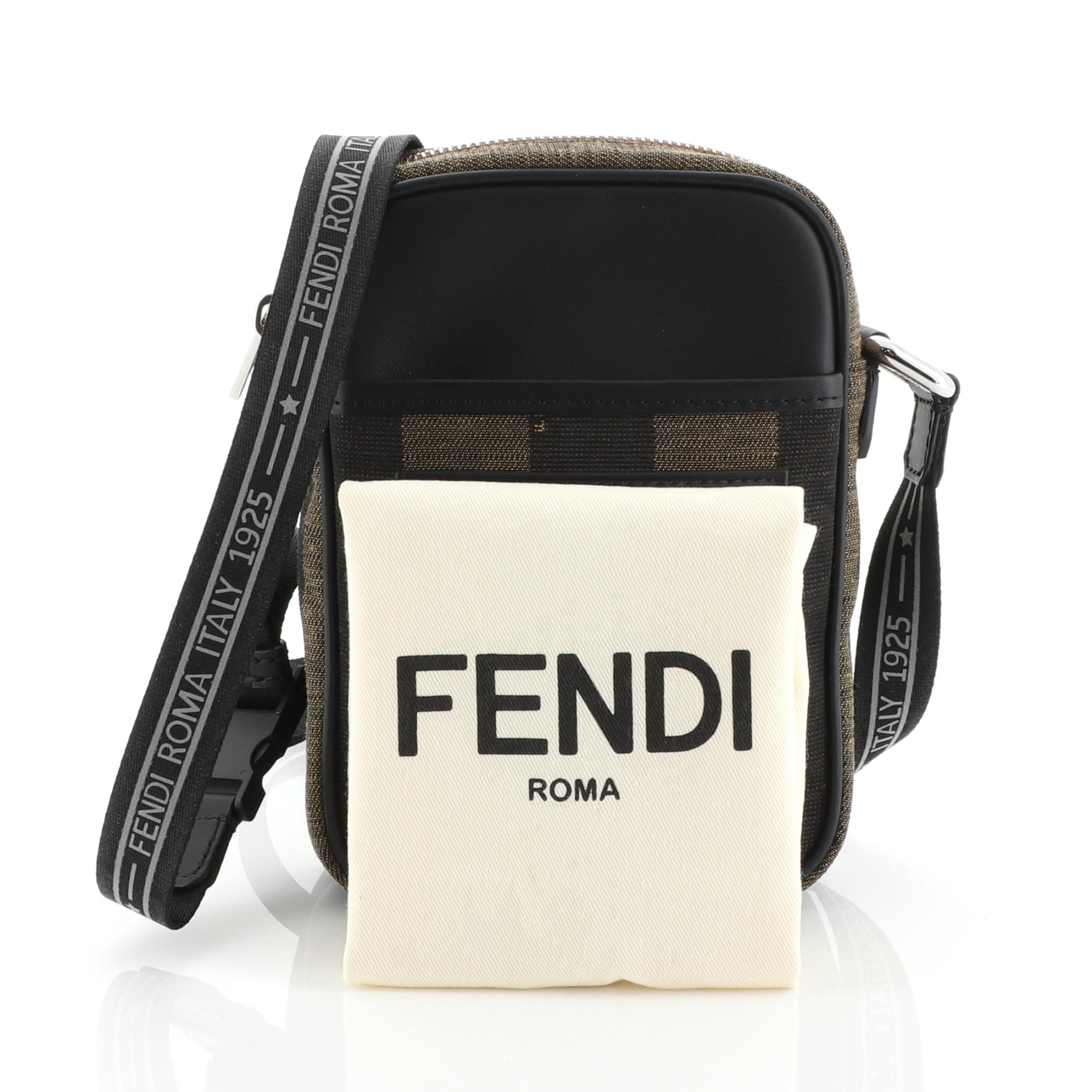 This Fendi Pequin Camera Crossbody Bag Canvas Mini, crafted in brown canvas and black leather, features adjustable shoulder strap, Fendi logo at front and silver-tone hardware. It opens to a red fabric interior. 

Estimated Retail Price:
