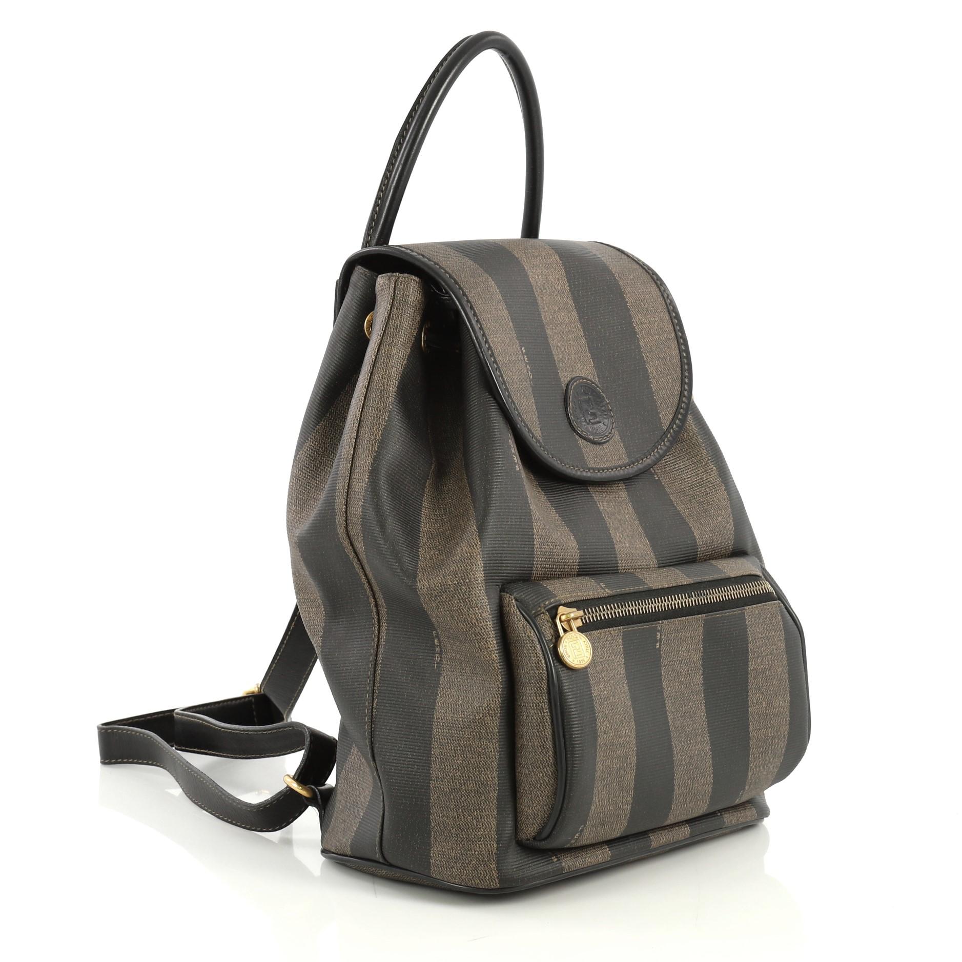 This Fendi Pequin Front Pocket Backpack Coated Canvas Medium, crafted from brown coated canvas, features rolled top handle, adjustable shoulder straps, exterior front zip pocket, and gold-tone hardware. Its flap and drawstring closure opens to a