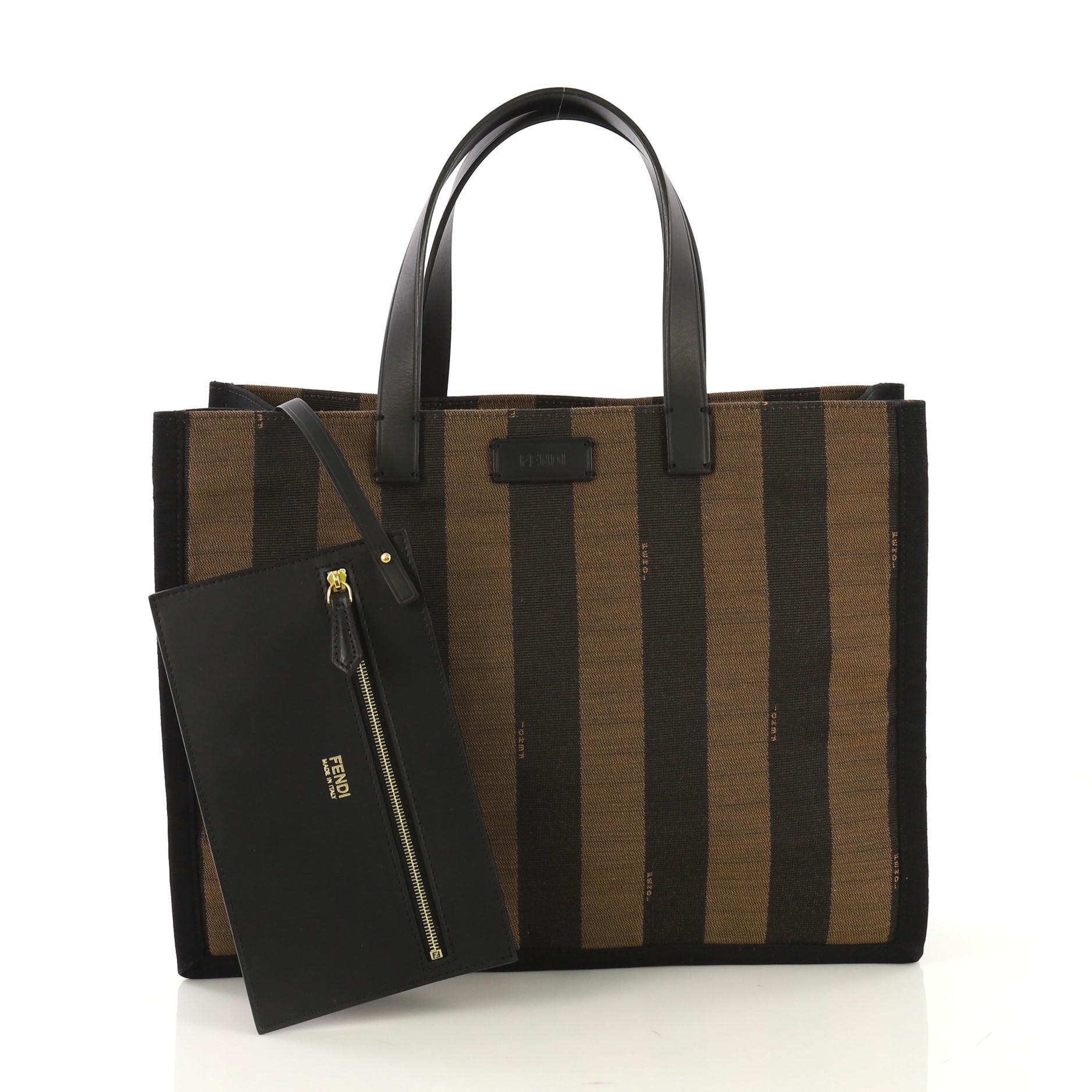 This Fendi Pequin Shopping Tote Canvas Medium, crafted in back and brown canvas, features dual flat leather straps and gold-tone hardware. It opens to a brown fabric interior. 

Estimated Retail Price: $1,400
Condition: Excellent. Minor wear on base