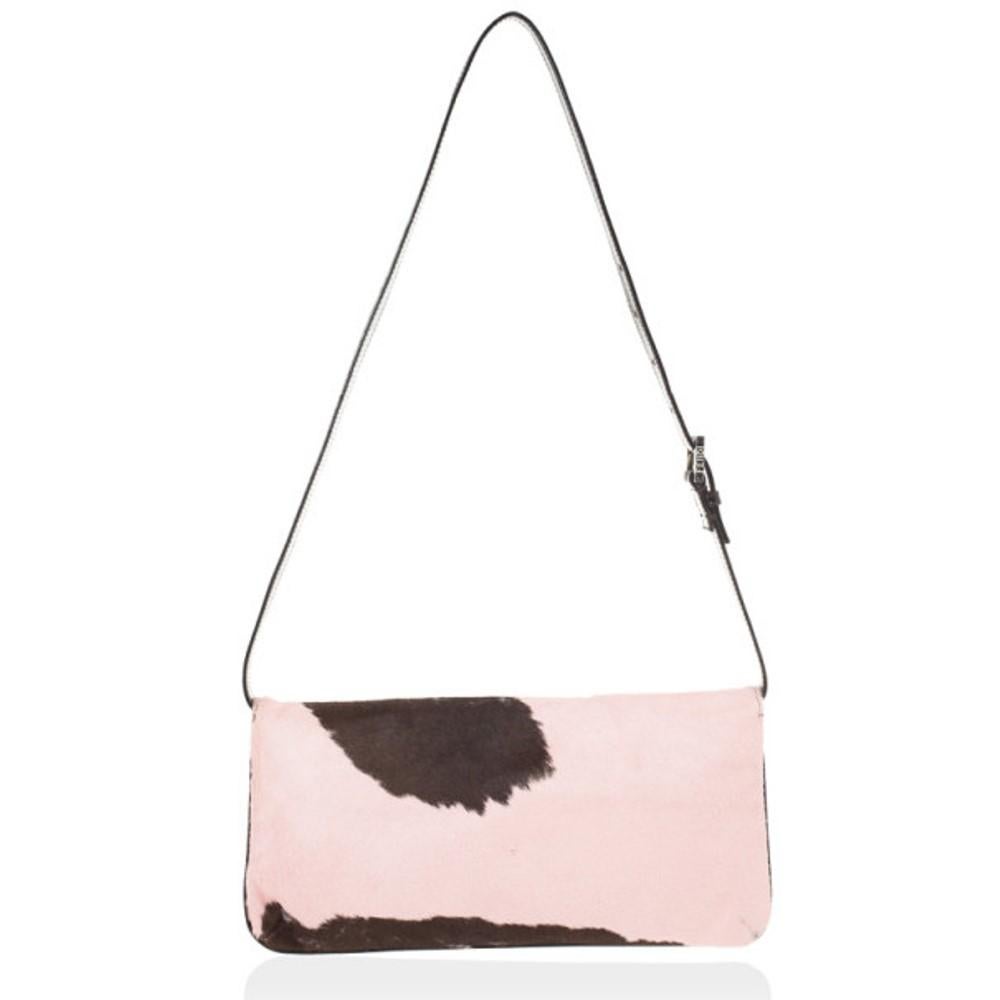 From the late 90's collection, this Fendi baguette in pony hair is very rare! Made from pony hair in pink and brown cow print, this shoulder bag is finished with brown leather trim and an adjustable handle. The flap snap closure opens to satin lined