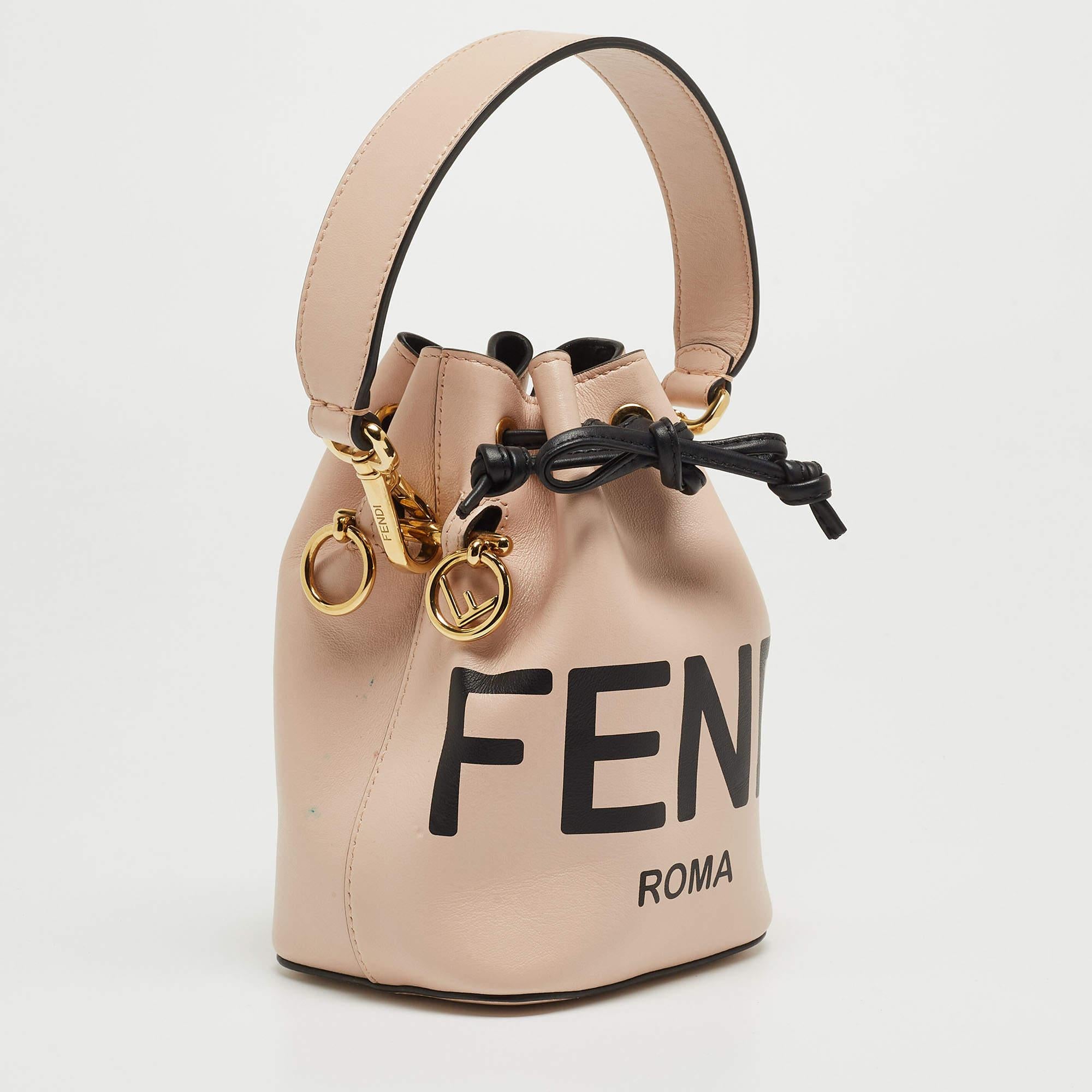 This wonderful Fendi design is made from leather and enhanced with gold-tone hardware. The bag has a bucket shape with a drawstring closure that secures the Alcantara interior. Complete with a top handle, it is an apt accessory to carry your