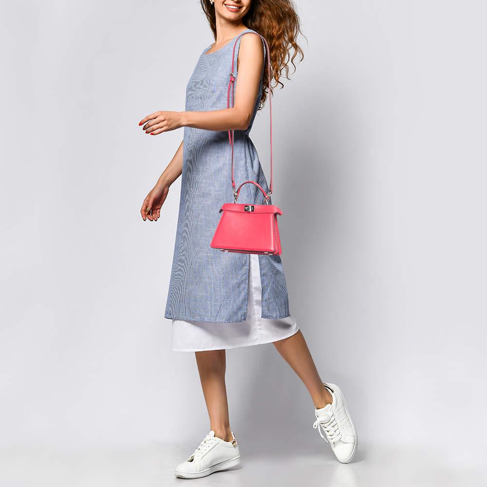 Le sac à main Icone Peekaboo de Fendi incarne le luxe avec son cuir et son design peekaboo emblématique. La couleur rose ajoute une touche de sophistication, tandis que la poignée supérieure offre une allure à la fois classique et moderne. Ce
