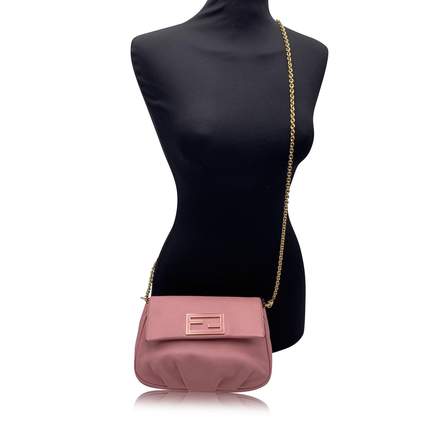 Hübsche Fendi 'Fendista' kleine Crossbody-Tasche aus rosa Leder. Sie hat einen abnehmbaren goldenen Metallkettenriemen, eine Klappe mit Magnetknopfverschluss mit emailliertem FF - FENDI Logo auf der Klappe und Drapierungen auf der Vorderseite. Rosa