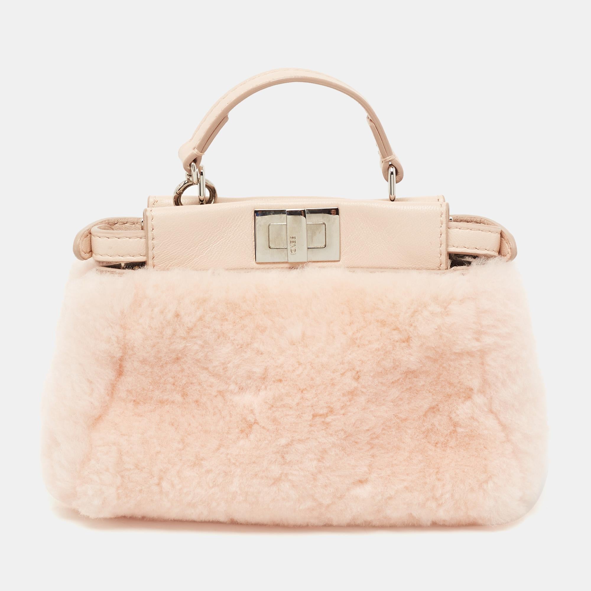 Fendi is synonymous with luxurious style. This Peekaboo bag is crafted with Shearling and leather and features silver-tone hardware and a top handle. Its twist-lock closure opens to a suede interior. The powder pink bag will be perfect for quick