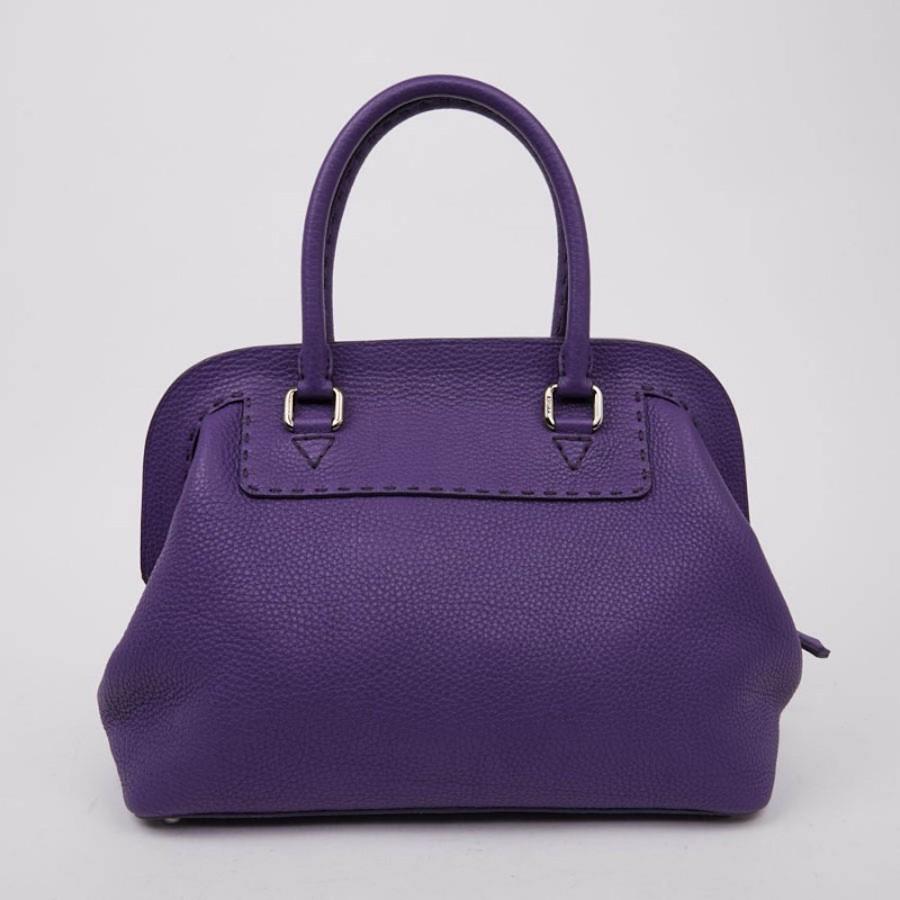 
FENDI bag in grained purple leather. It has a long zipper on a rigid frame. The jewelry is in palladium silver metal. The interior is lined in suede with a zipped pocket. The bag is in perfect condition, the corners are  patinated. Serial number: