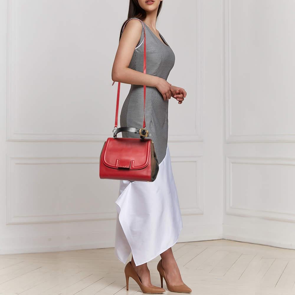 This Silvana bag by Fendi has a sophisticated look. Crafted from leather and pequin stripe canvas, the bag is held by a top handle and a shoulder strap. The bag comes with protective metal feet and a flap that opens to a spacious suede and fabric