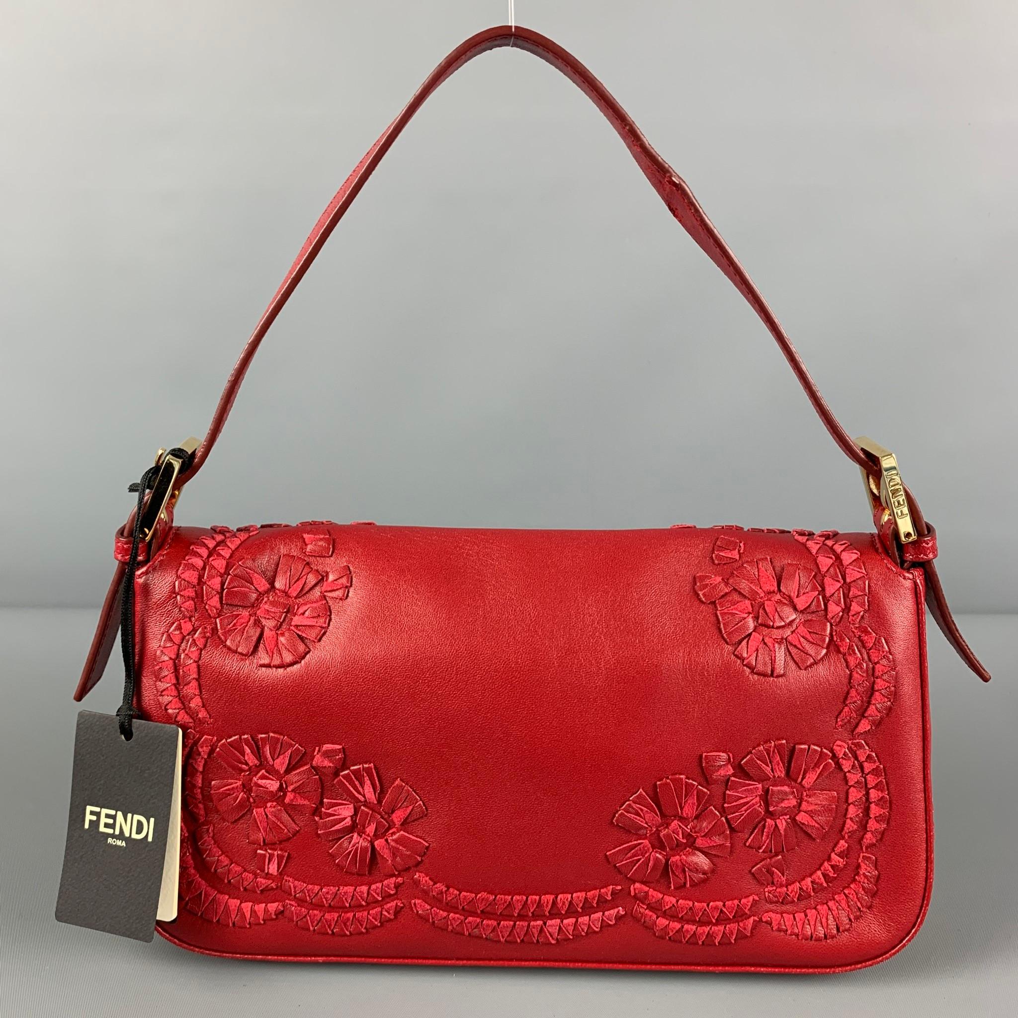 FENDI bag comes in a red leather featuring signature baguette design, triangolo printed flower details, gold tone hardware, inner slot, adjustable top handle, and a snap button closure. Includes tags and dust bag. Made in Italy. 

Very Good