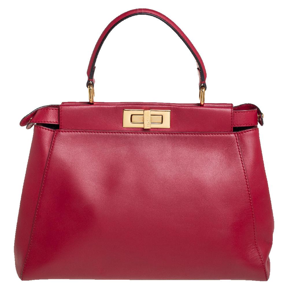 This exquisite Peekaboo from Fendi is highly coveted, and since its birth in 2009, it has swayed us with its shape, design, and beauty. This version comes meticulously crafted from red leather and designed with a top handle for you to swing it. A