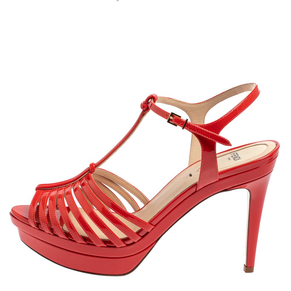 Finely crafted from patent leather in t-bar style, these Fendi sandals come ready to give you a high-fashion experience. The red sandals feature platforms, buckle ankle fastenings, and 10 cm heels.

Includes: Original Box, Info Booklet, Extra Heel