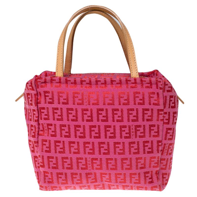 A Fendi classic, this red and pink pochette is exquisite. It is crafted from the brand's signature Zucchino canvas that is fashionable and durable. It features two handles crafted from leather for convenience and its canvas-lined interior is