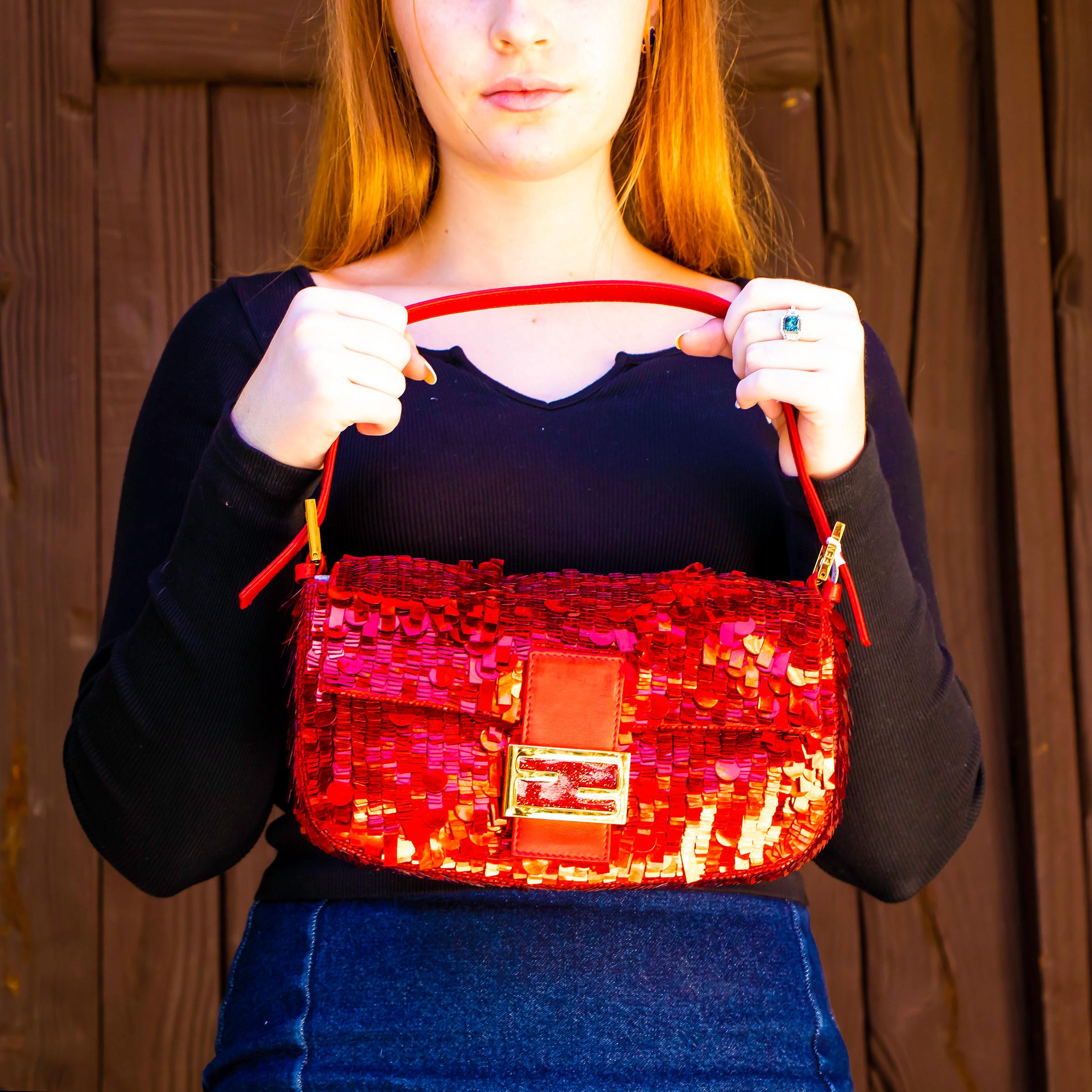 Beautiful red Fendi sequence clutch with matching strap. This bag has one main pocket with one small zippered section and a deep purple lining. It also has a magnetic closure and red leather accents. Made in Italy.

Height = 6 inches
Width = 11