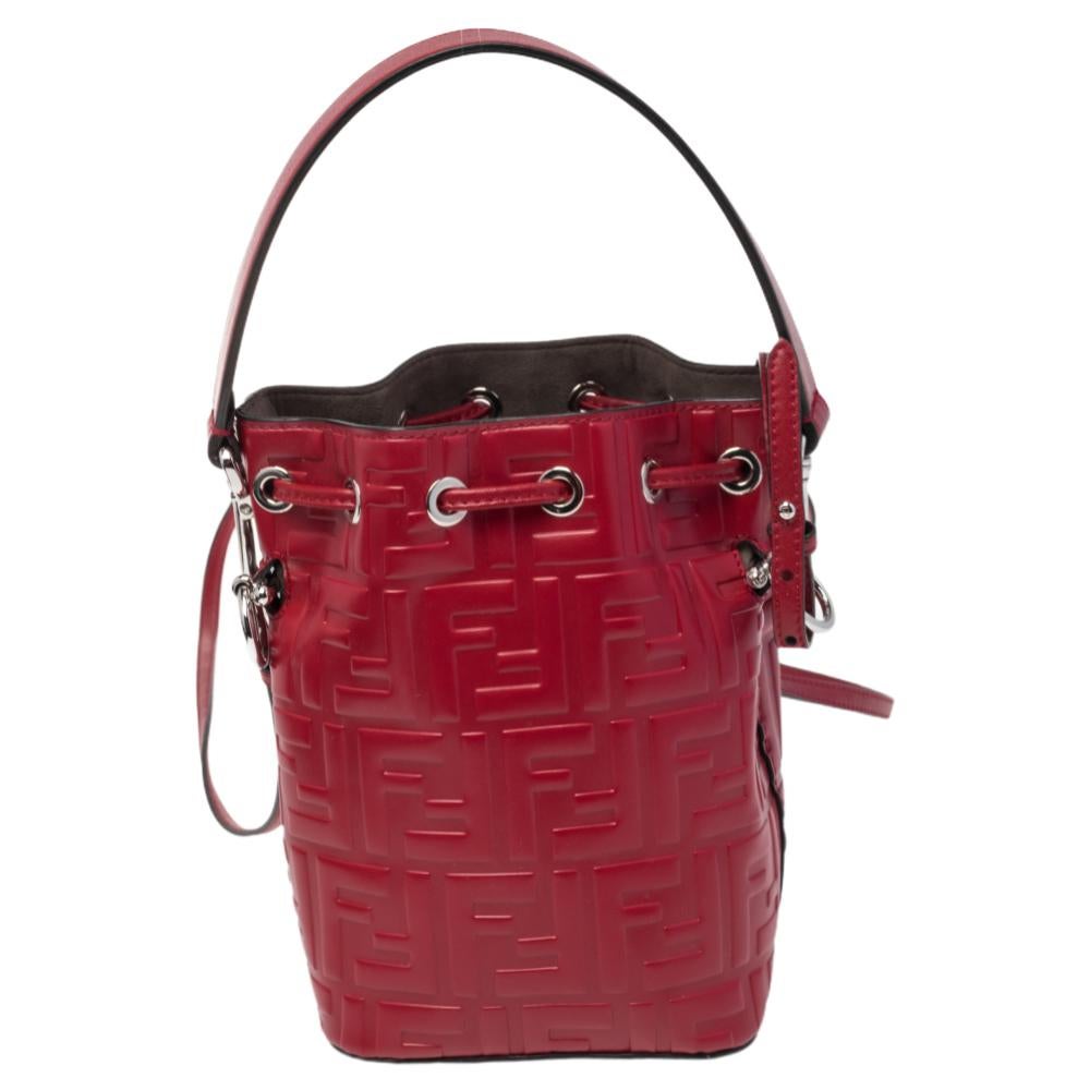This wonderful Fendi design is made from Zucca leather and enhanced with silver-tone hardware. The bag has a bucket shape with a drawstring closure that secures the suede interior. It is complete with a single handle and a shoulder strap. Red in