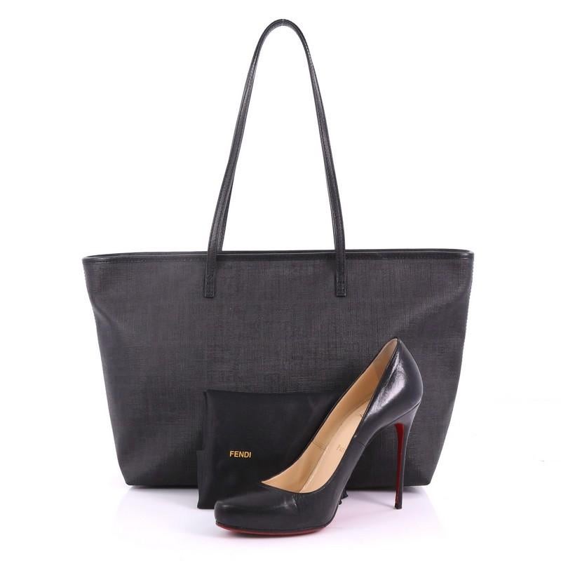 This Fendi Roll Tote Zucca Coated Canvas Medium, crafted in black zucca coated canvas, features dual slim handles and gold-tone hardware. Its wide open top showcases a black fabric interior with side zip pocket. **Note: Shoe photographed is used as