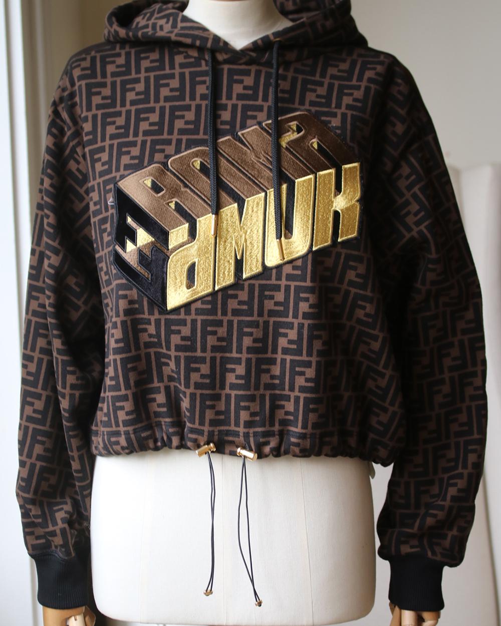 For the new season, Fendi is in utility mode. From exaggerated pockets to the always present logomania motifs, expect to see some serious ready-to-wear magic from the label. Spun Tobacco brown and black cotton. This Fendi Roma Amor sweatshirt