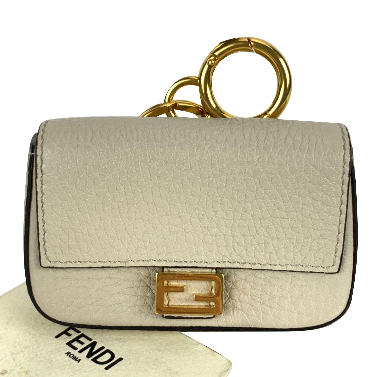 Lovely Fendi 'Nano Baguette' Key bag charm in off-white leather (official color is 'Latte'). This is the micro version of the iconic. Baguette bag. It features a flap front with magnetic button, gold metal FF logo on the front, a key ring on top and