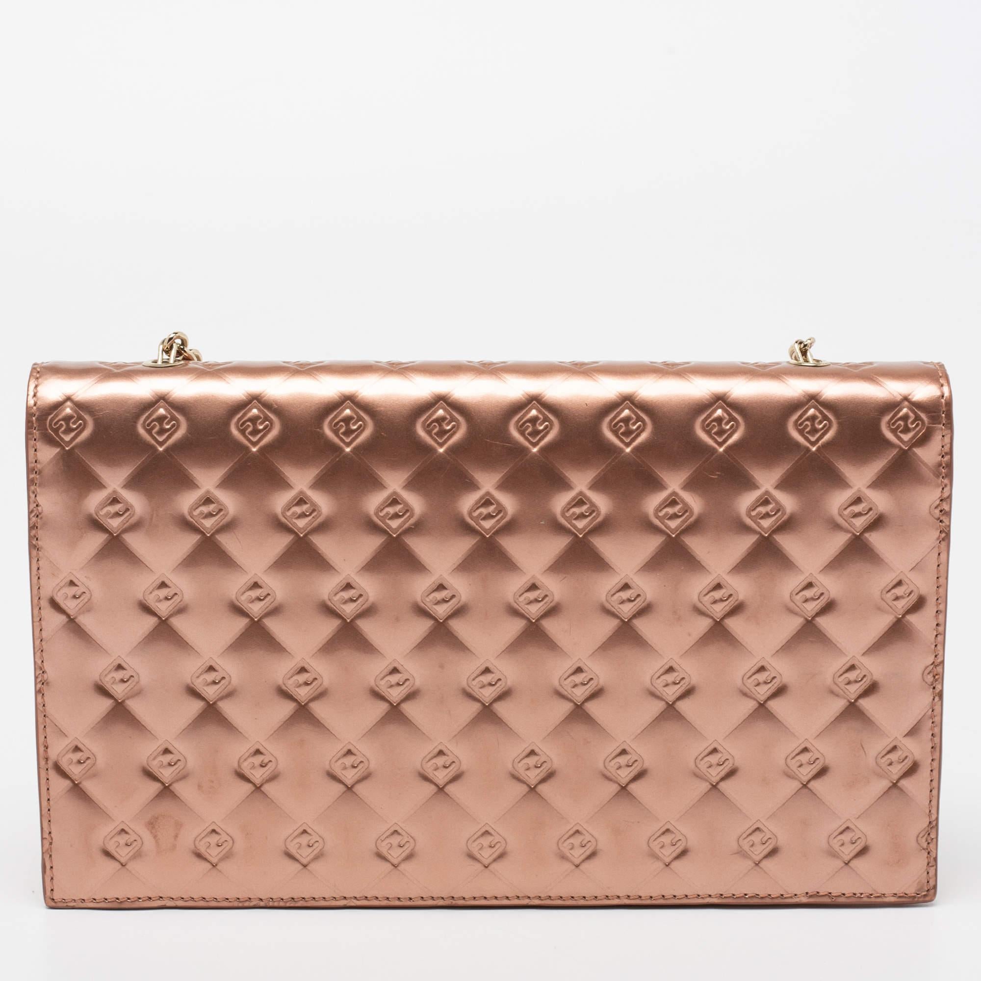 This stylish rose gold bag from Fendi is undoubtedly a fashionista's choice! Crafted in patent leather, this Fendilicious WOC has the signature FF logo embossed all over. The bag features a front logo, an interlinked chain strap, and a wallet-like