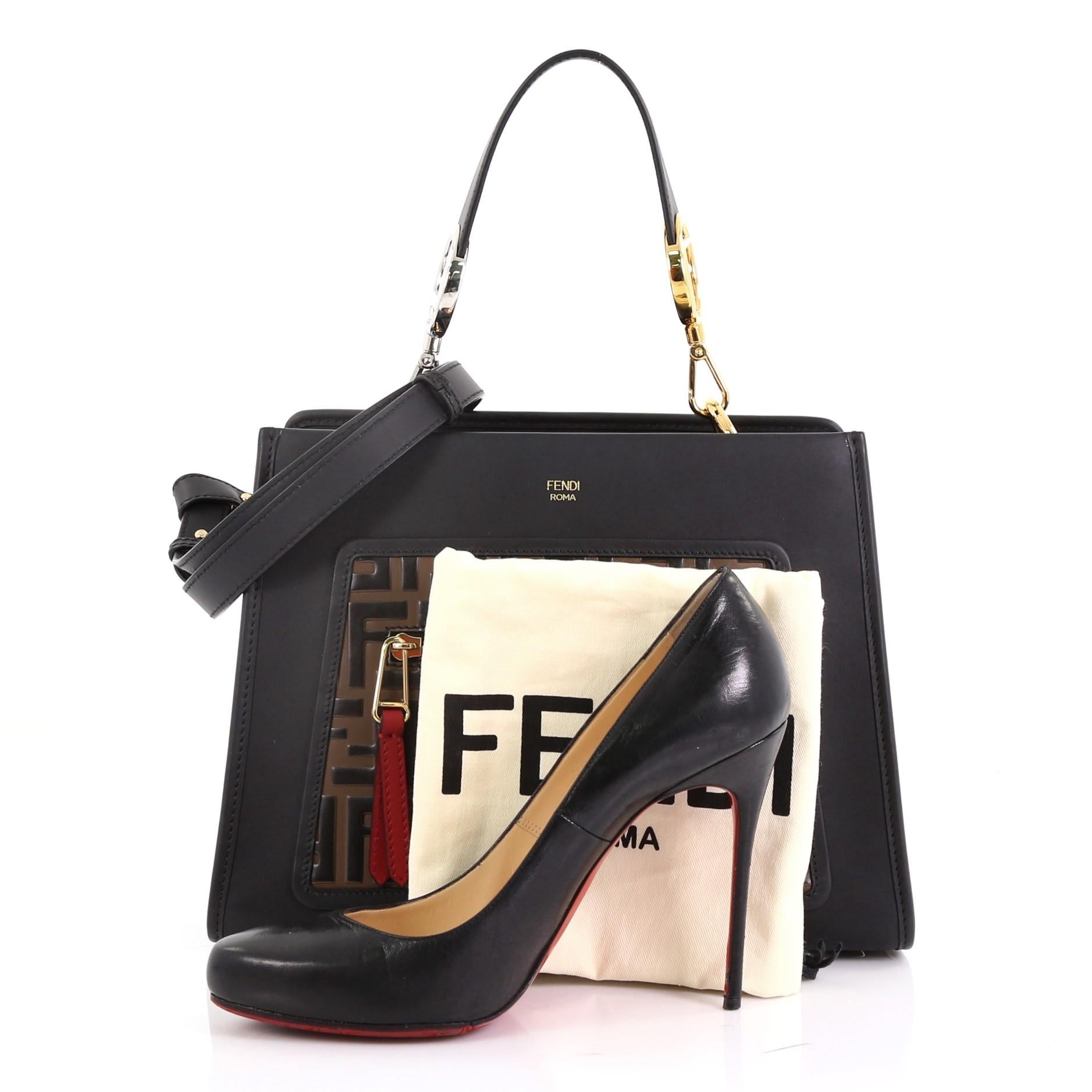 This Fendi Runaway Handbag Leather and Logo Embossed Leather Small, crafted in black and brown leather and logo embossed leather, features a removable flat top handle, exterior zip pocket, protective base studs, and silver and gold-tone hardware.