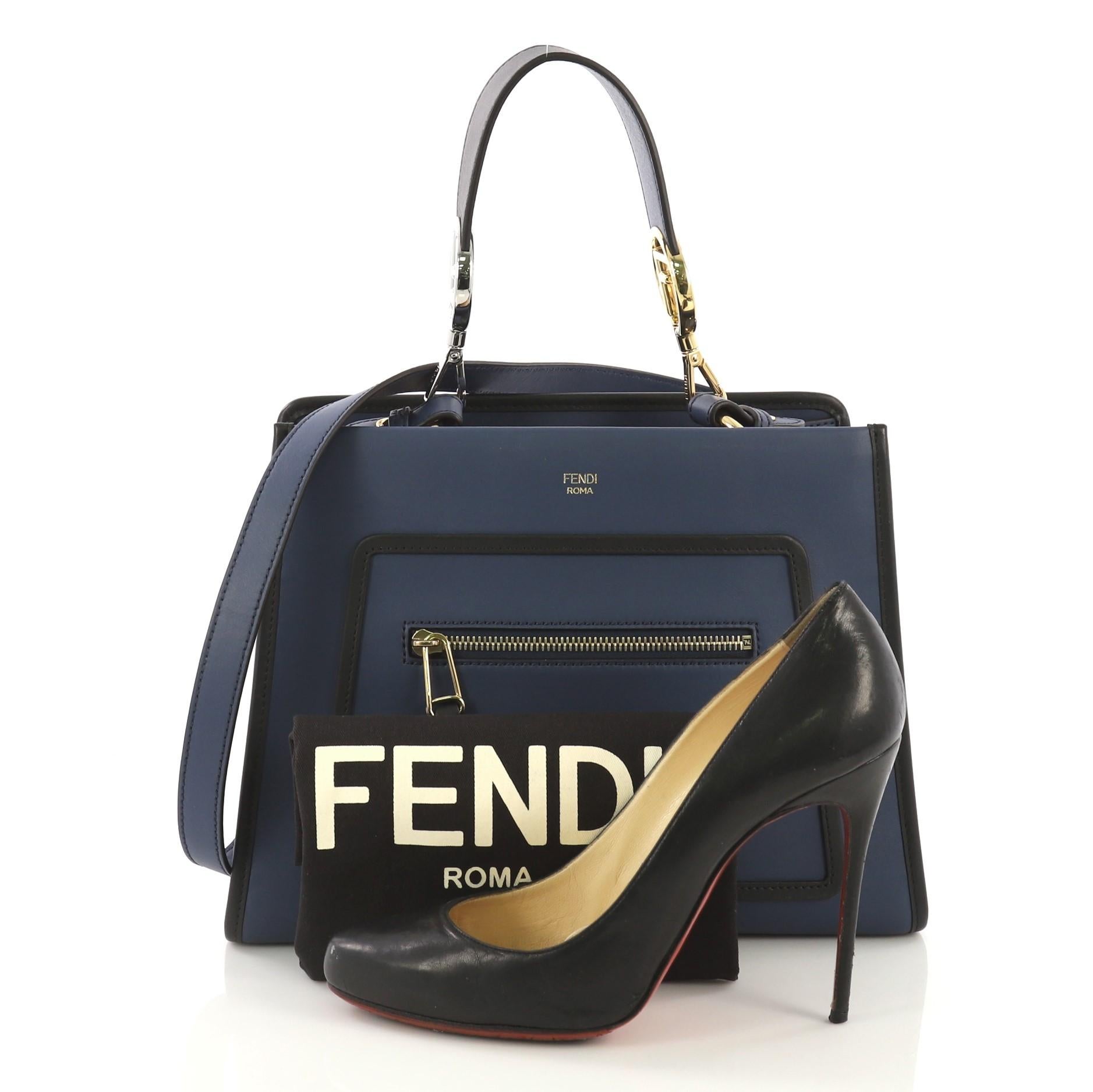 This Fendi Runaway Handbag Leather Small, crafted from navy leather, features a flat leather handle, exterior zip pocket, and silver and gold-tone hardware. Its magnetic snap button closure opens to a taupe microfiber interior with zip and slip