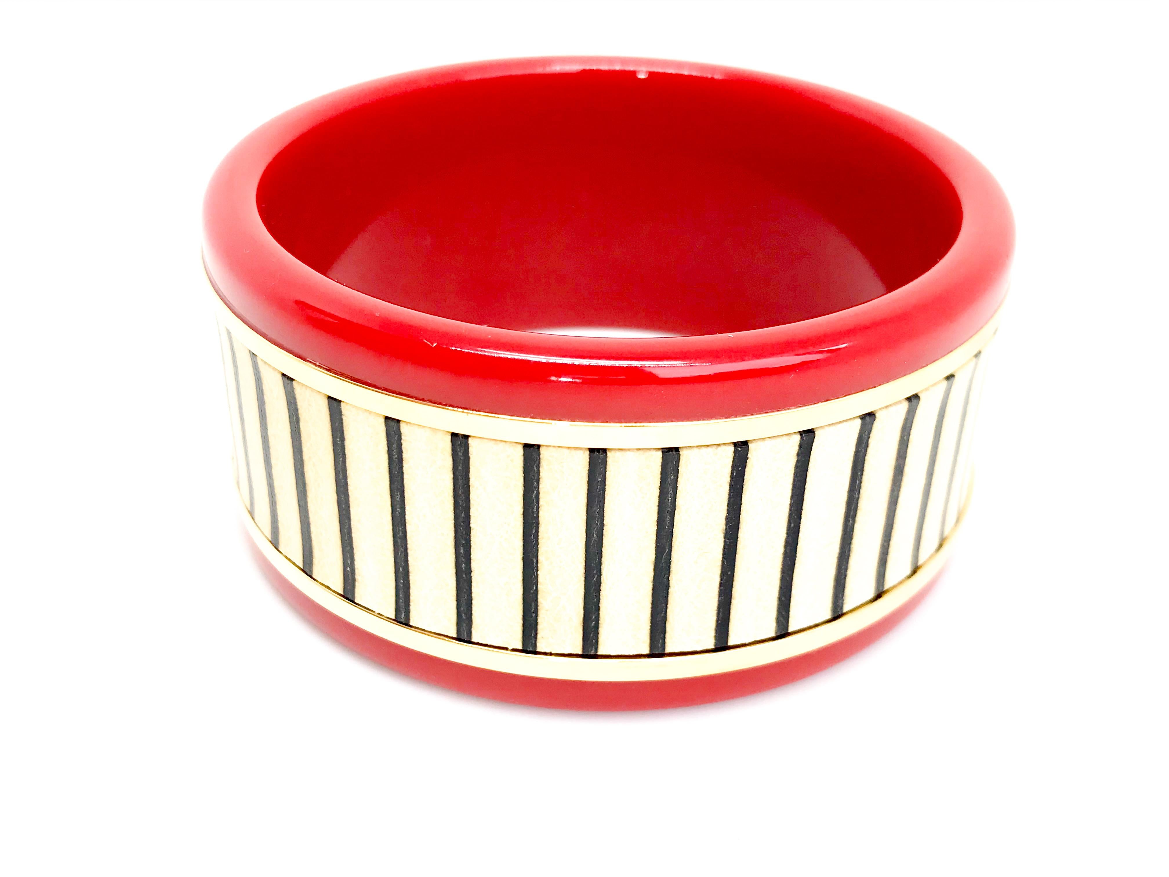 Red resin Fendi bangle featuring striped vitello leather inlaid into gold tone metal featuring Fendi signature.  Stamped made in Italy inside.

As featured on Fendi runway.  Please message me for photo of this as too small to upload to site.

Can be