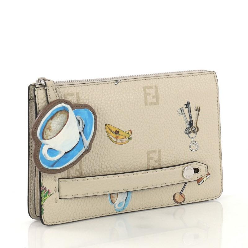 This Fendi Selleria Clutch Printed Leather Medium, crafted from beige printed leather, features slot handclasp and silver-tone hardware. Its zip closure opens to a dark brown and beige leather interior divided into three compartments with side zip