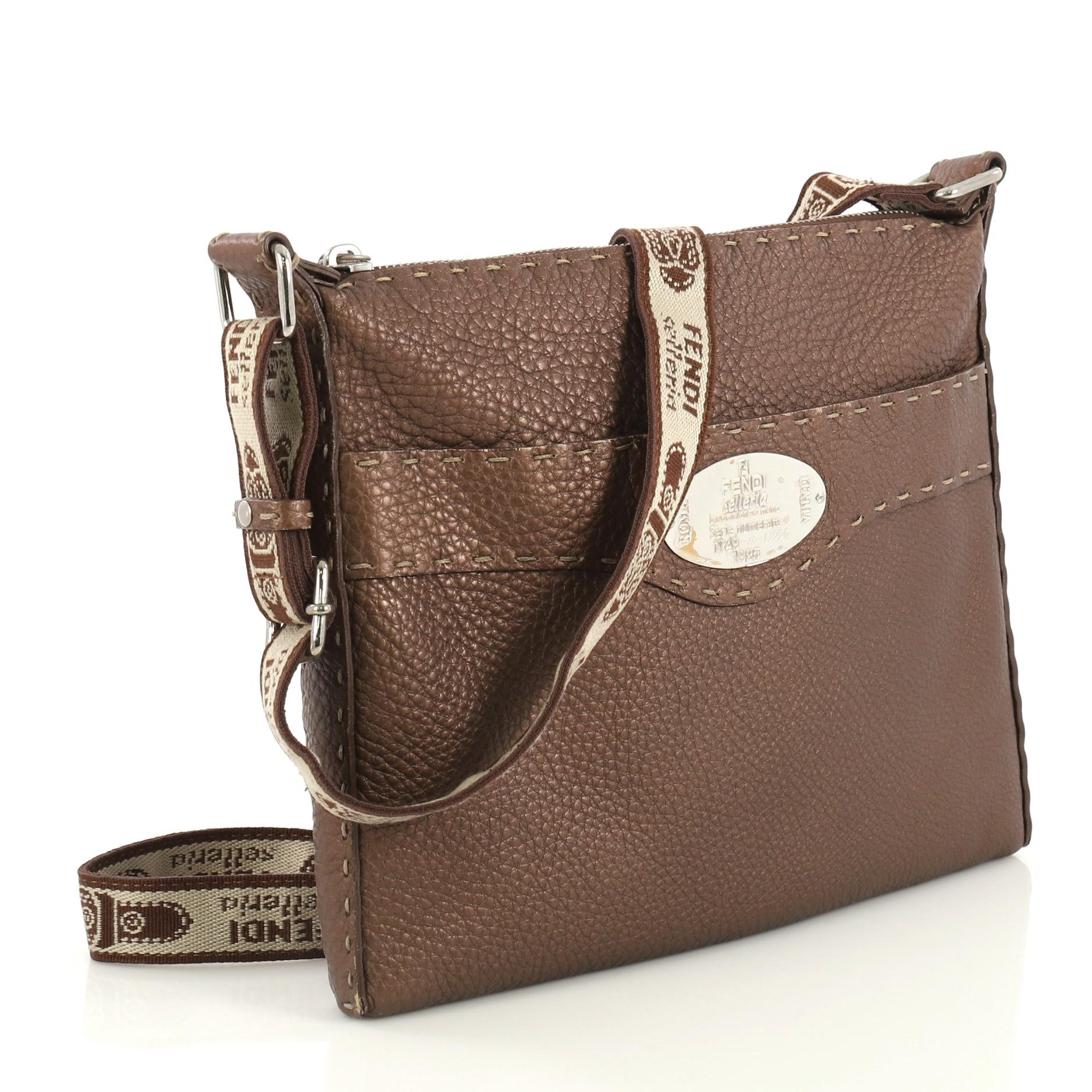 This Fendi Selleria Crossbody Bag Leather Small, crafted in brown leather, features an adjustable crossbody strap and silver-tone hardware. Its zip closure opens to a brown fabric interior with zip pocket. 

Condition: Very good. Moderate wear on