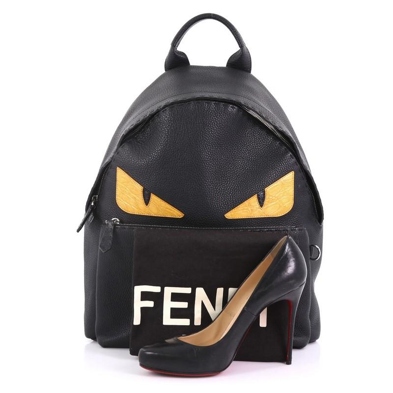This Fendi Selleria Monster Backpack Leather Large, crafted from black leather, features eye-catching monster eye design, a flat top handle, padded, adjustable shoulder straps, exterior front zip pocket, and silver-tone hardware. Its two-way zip