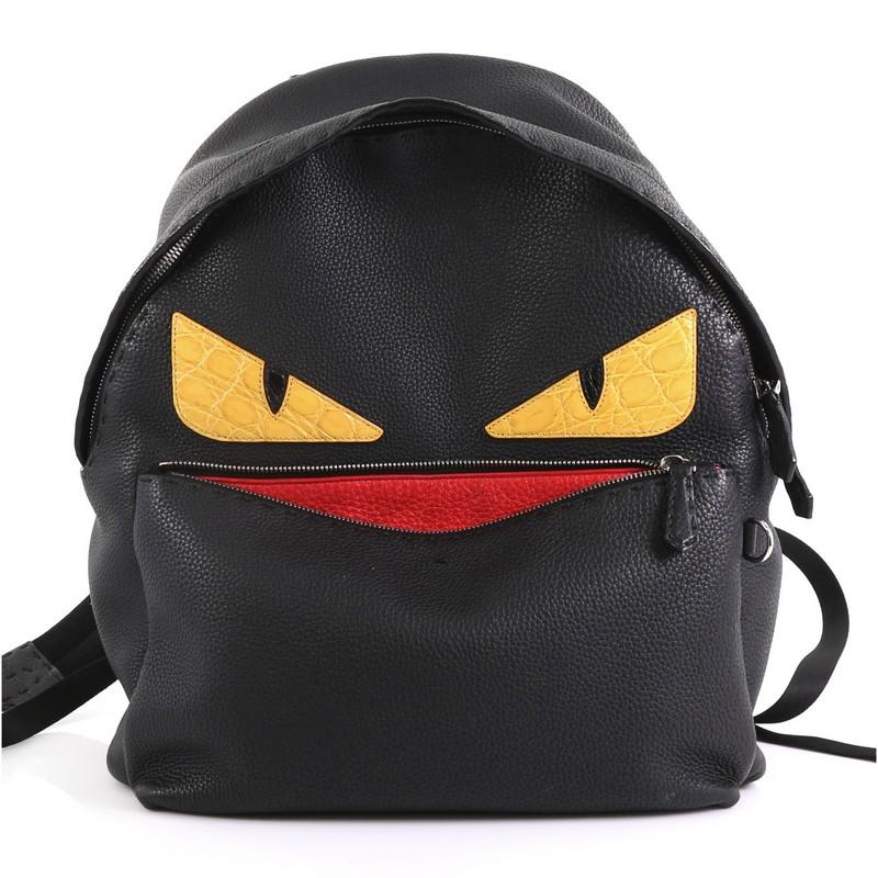 This Fendi Selleria Monster Backpack Leather Large, crafted from black leather, features monster eye design, leather top handle, padded shoulder straps, exterior front zip pocket, and silver-tone hardware. Its two-way zip closure opens to a black