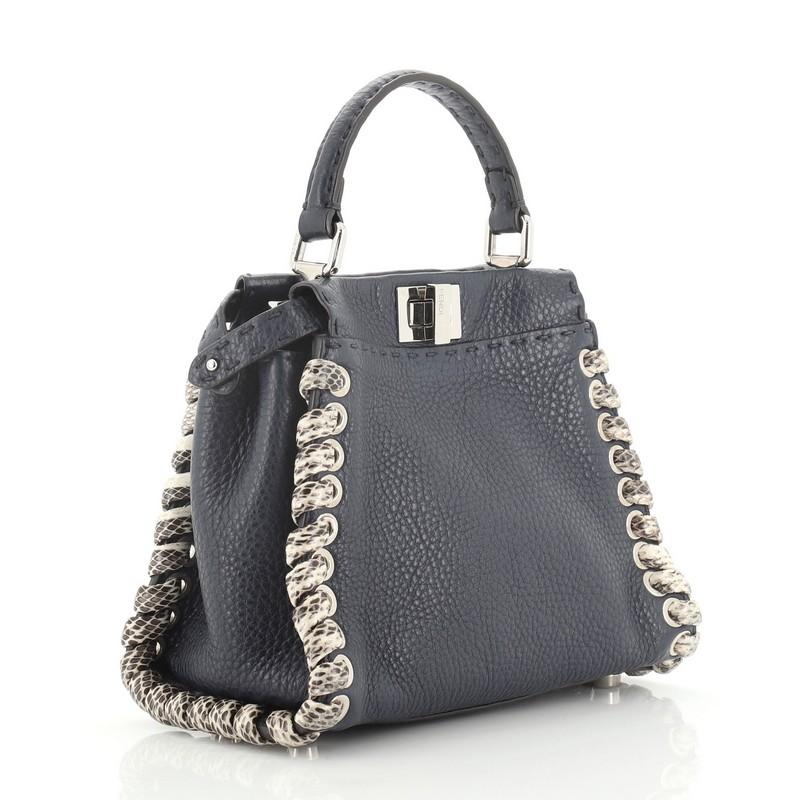 This Fendi Selleria Peekaboo Bag Leather with Python Whipstitch Mini, crafted from blue leather with genuine python skin whipstitch detailing, features a top frame silhouette, flat leather handle, and silver-tone hardware. Its turn-lock and snap
