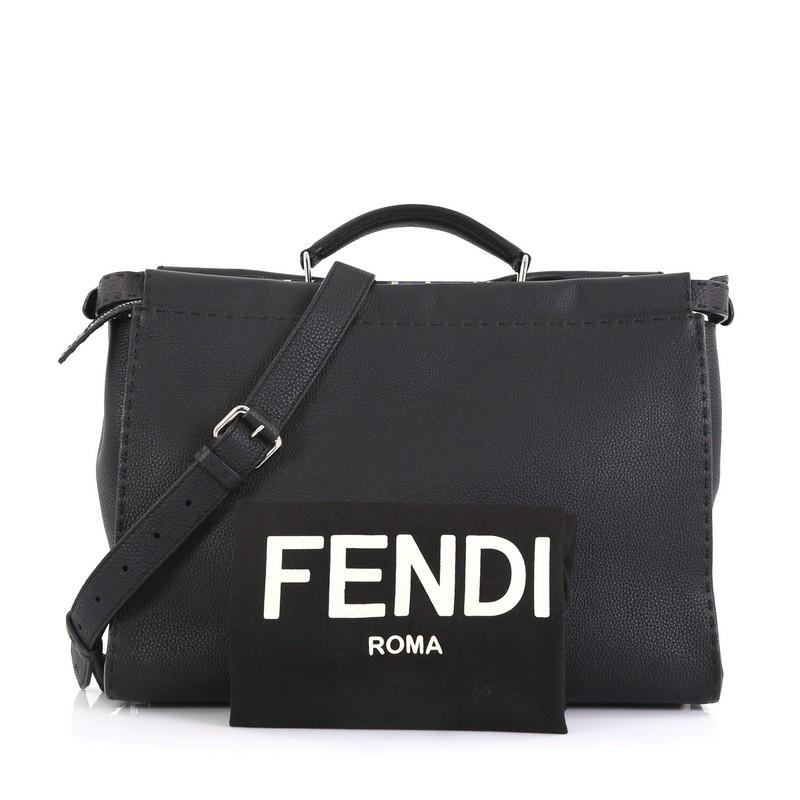 This Fendi Selleria Peekaboo Bag Leather XL, crafted from black leather, features short leather top handle and silver-tone hardware. Its two compartments with press-lock and zip closures open to a blue leather and black microfiber interior with side