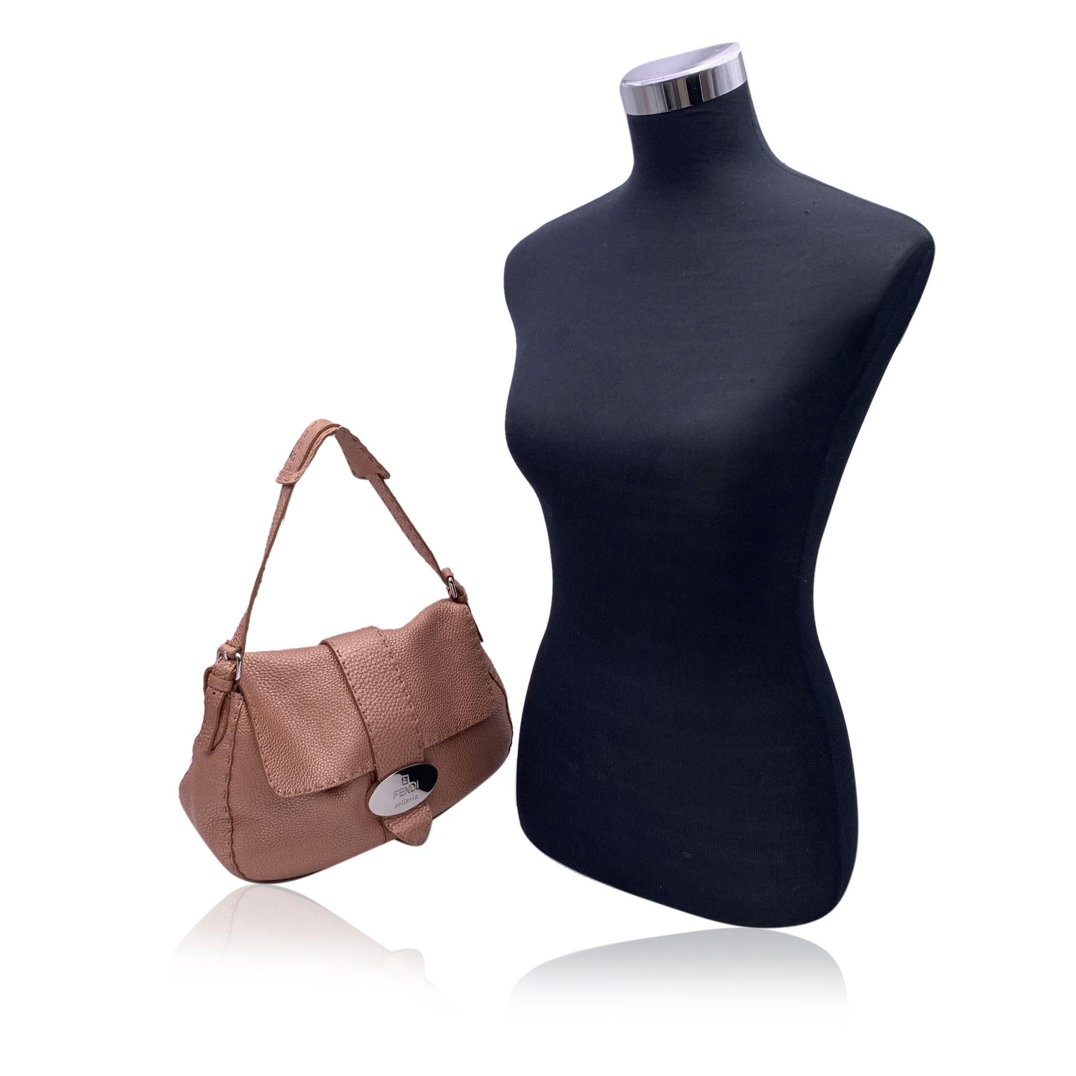Gorgeous FENDI SELLERIA shoulder bag, handcrafted by FENDI master saddlers. The bag is crafted in pink rose pebbled 'Cuoio Romano' leather. It features flap with magnetic button closure and silver metal FENDI SELLERIA logo plaque on the front. Beige