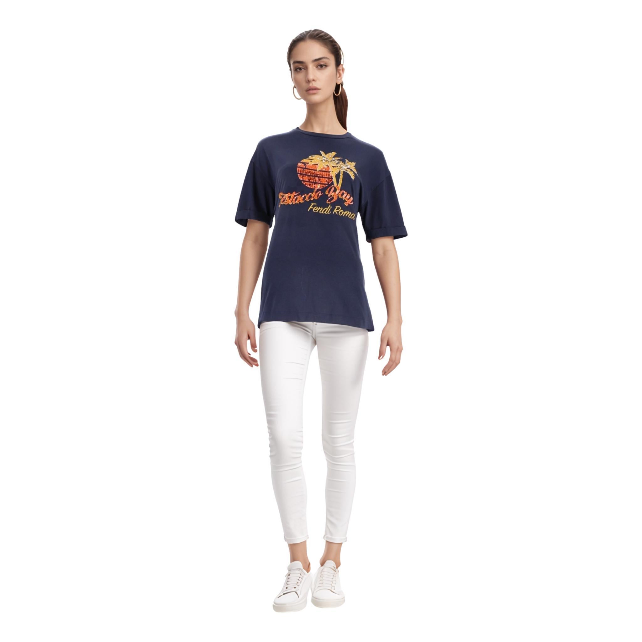 Top con logo in cotone con patch di paillettes Fendi

T-shirt navy in cotone impreziosita da patch di paillettes arancioni e stampa di palme al centro con firma 'Fendi Roma'.

Maniche corte, vestibilità rilassata e spacchi laterali. Prezzo di