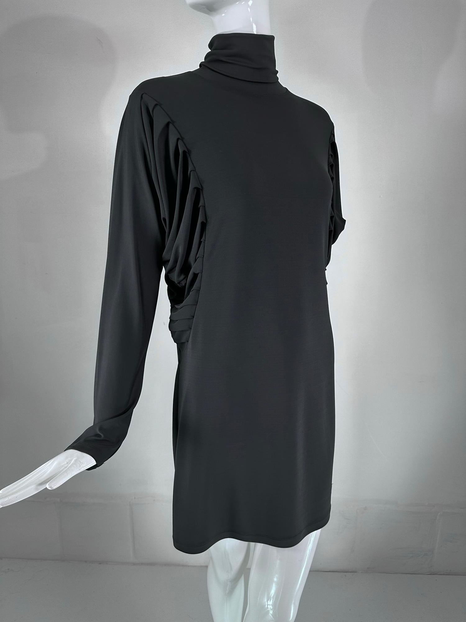 Fendi silky black jersey pleated bat wing turtle neck dress marked size 40. Pull on stretch jersey dress has a turtle neck, long bat wing style, with pleats at the underside of the upper arm, fitted at the lower part of the arm. The dress is cut