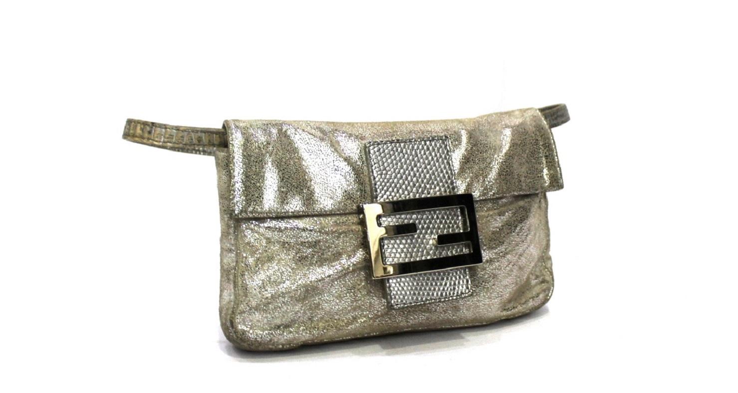 Fendi Mini Baguette in silver laminated leather with silver hardware.
Magnetic button closure, not very large inside.
equipped with a removable leather handle.
The bag shows some signs of wear.