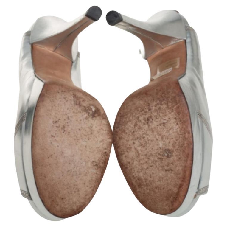 Featuring a chic design, these pumps from Fendi are easy to style. The silver patent leather body showcases high heels and peep toes to form a distinctive outline. Their simple design works equally well with casual dresses and formal wear.