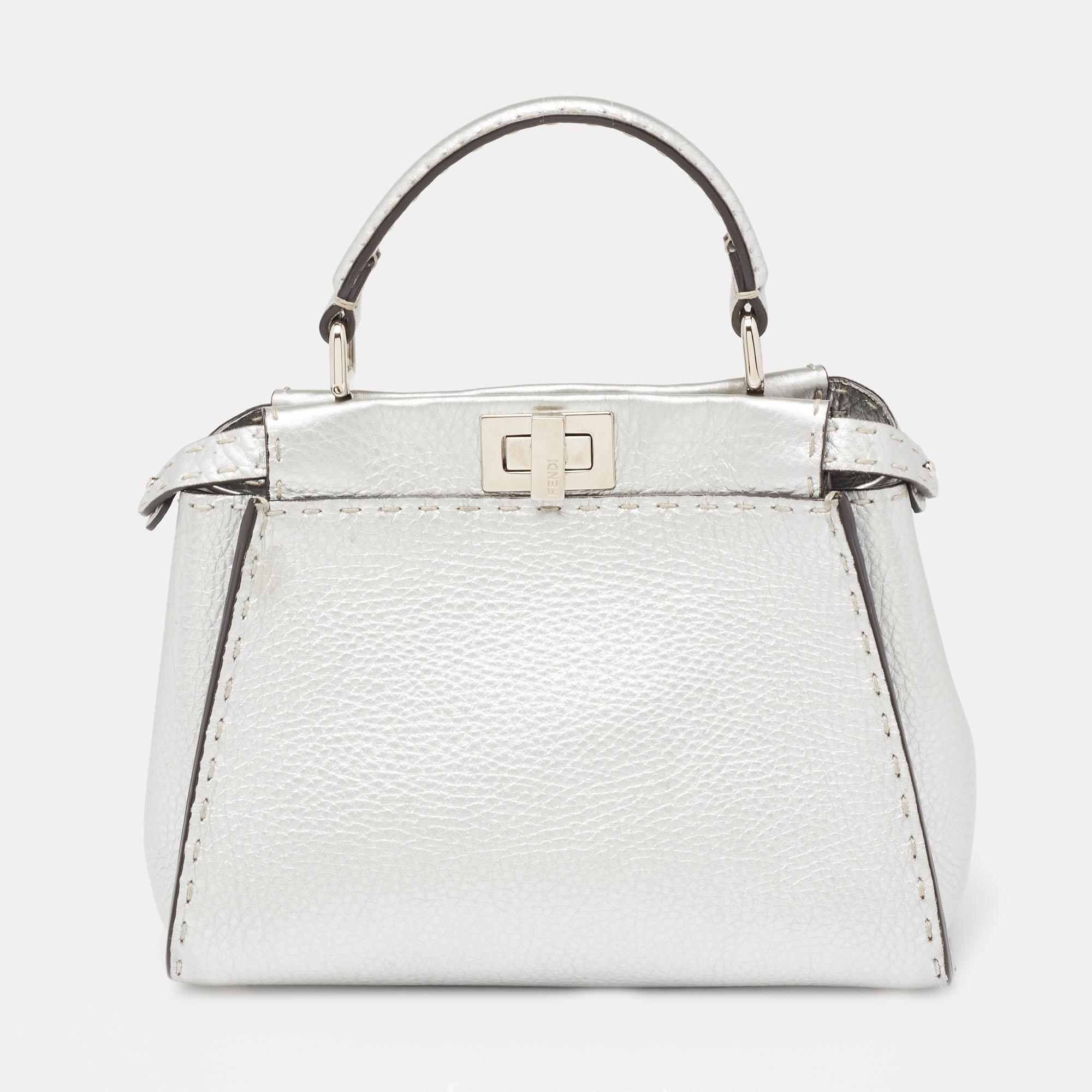 The unique construction and representation of this Fendi Mini Peekaboo bag enable it to keep up with fashion's ever-changing tide. Constructed from leather, it is complemented with silver-tone hardware, a single handle, and a shoulder strap. The