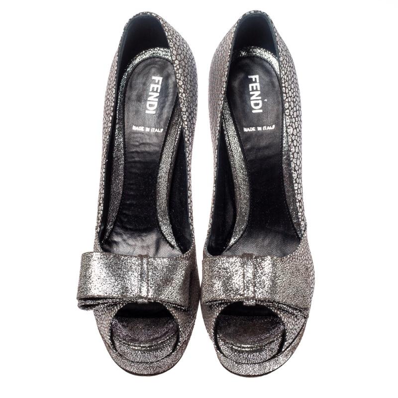 Look classy in this pair of pumps designed by Fendi. Made from silver-hued textured fabric, they have sophisticated 14 cm heels and bow detailing on the uppers. These pumps feature peep toes and insoles that are lined with leather.

