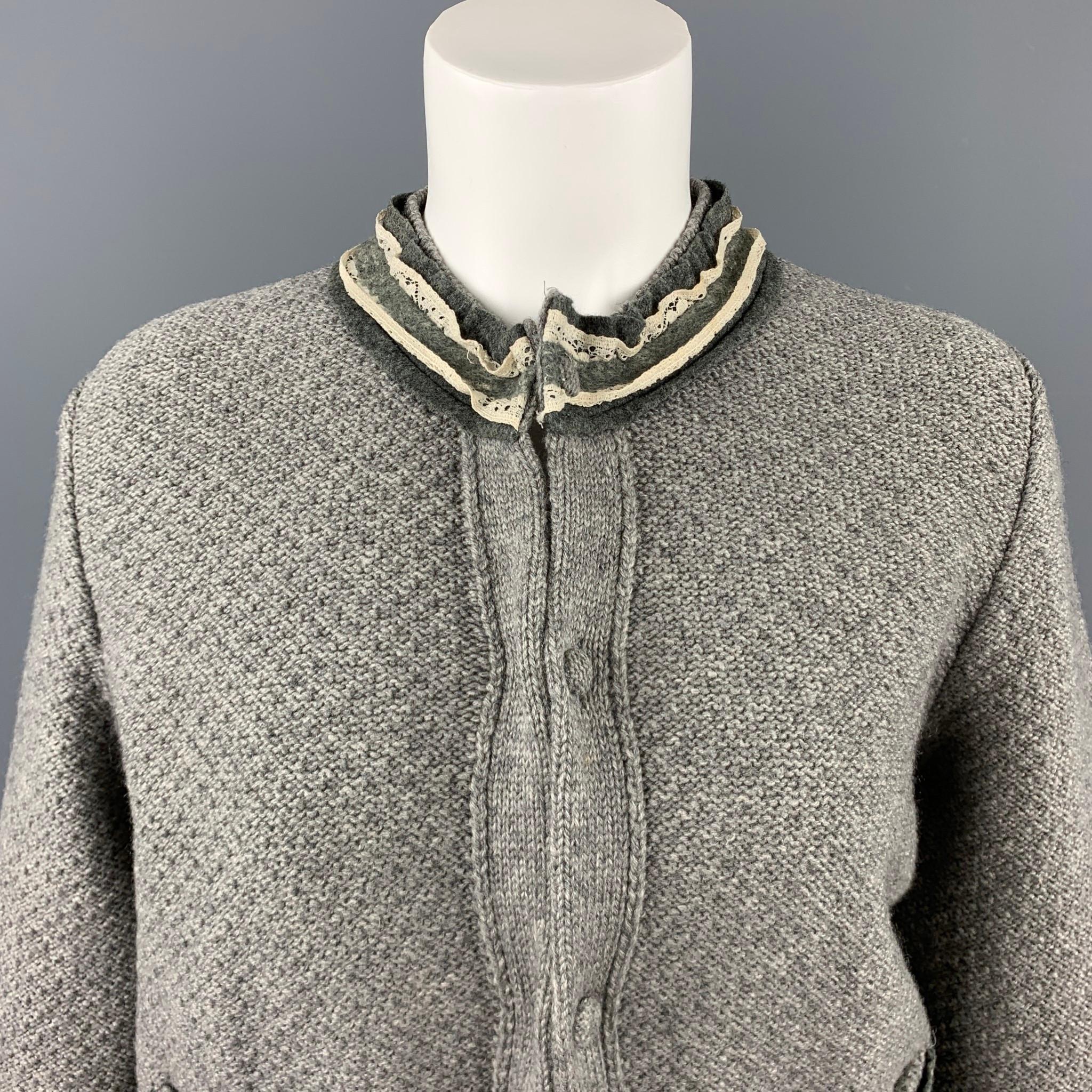 FENDI cardigan comes in a gray knitted wool featuring 3/4 sleeves, crew-neck with trimmed ruffles, patch pockets, and a hidden button closure. Made in Italy.

Excellent Pre-Owned Condition.
Marked: IT 40

Measurements:

Shoulder: 15 in.
Bust: 42